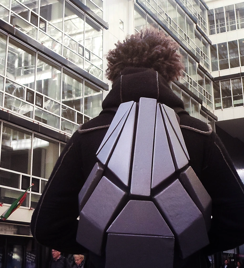 The faceted REK backpack worn outdoors, viewed from behind